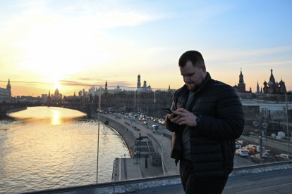 Moscú. Un hombre usa su teléfono inteligente en el puente flotante (Puente Paryashiy) en el parque Zaryadye, en el centro de Moscú.