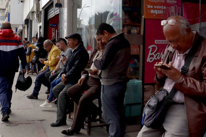 Cambistas esperan clientes en una calle comercial de Ipiales, en la frontera con Ecuador.