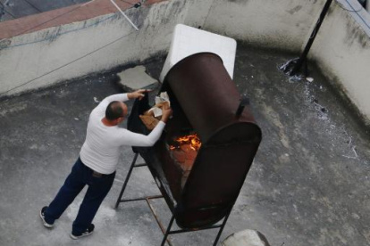 Un hombre quema papeles en la terraza de la Embajada de Cuba en Quito.