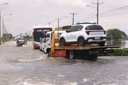 1. Problemas. Muchos vehículos quedan dañados y otros optan por pagar hasta $30 a las grúas para atravesar la zona más anegada de la carretera. Personas también guían a los carros, por $1 o $2.