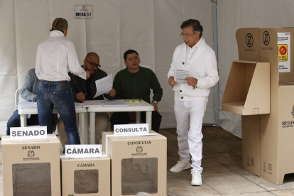 El presidente de Colombia, Gustavo Petro, sostiene las papeletas para Senado y Cámara antes de votar este domingo, en Bogotá.