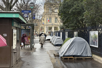Migrantes viven en tiendas de campaña en una céntrica calle de París.