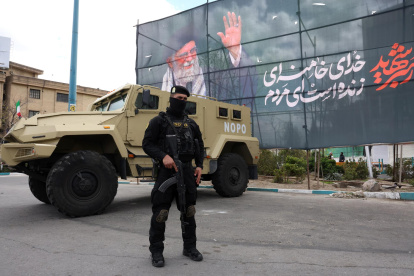 Un miembro de las fuerzas de seguridad iraníes monta guardia junto a una pancarta en honor al exlíder supremo iraní Ali Khamenei, en Teherán, Irán, el 30 de marzo de 2026.