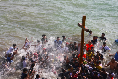 Entre plegarias y cánticos los pescadores de Ballenita bañaron la cruz