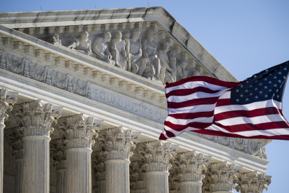 Foto que muestra una bandera estadounidense ondeando frente a la Corte Suprema de Estados Unidos en Washington D. C.