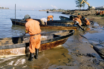 Fotografía de referencia de trabajadores petroleros contratados por la paraestatal Petróleos Mexicanos que limpian en una zona de un derrame de crudo.