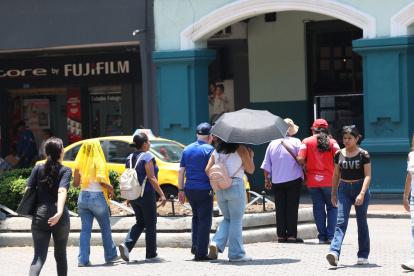 La ciudadanía utiliza sombrillas para protegerse del intenso sol que se registra en Guayaquil.
