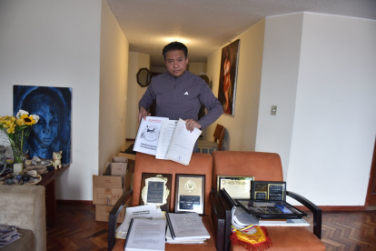 Jonnathan Carrera con varios  fotos de su padre y de los reconocimientos que recibió por su aporte para la identidad, normativa y masificación del ecuavóley.