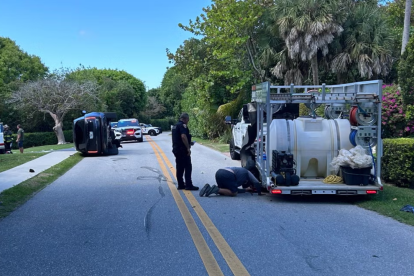 Agentes de policía custodian el perímetro tras el choque de la camioneta negra perteneciente a Tiger Woods