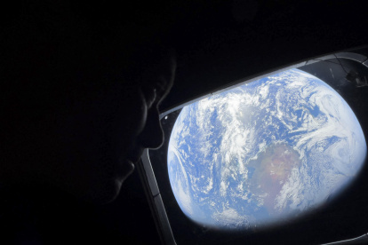 El comandante Reid Wiseman observa la Tierra mientras continúan adentrándose en el espacio hacia la Luna.