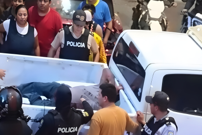 Agentes rodean un vehículo en la Zona Rosa de Machala mientras atienden a las víctimas del ataque armado.