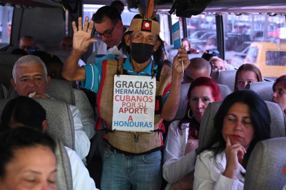 Un hombre saluda a médicos cubanos en un autobús tras su llegada al Aeropuerto Internacional de Palmerola, a 50 km al norte de Tegucigalpa, el 27 de febrero de 2024.