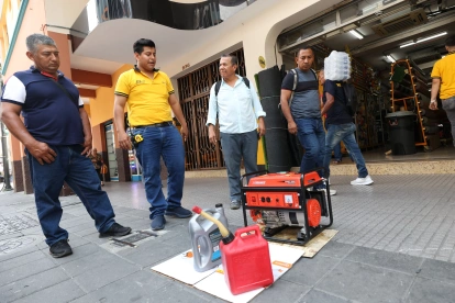 Un trabajador de la ferretería León, en Guayaquil, prueba un generador de energía eléctrica antes de entregar al comprador.
