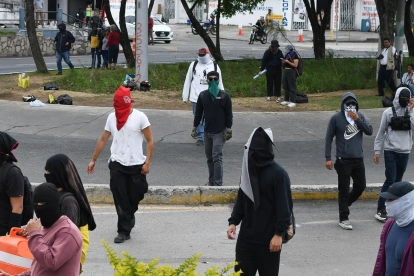 Encapuchados caminan durante una manifestación el 7 de abril de 2026, afuera de la Universidad de San Carlos de Guatemala (Guatemala).