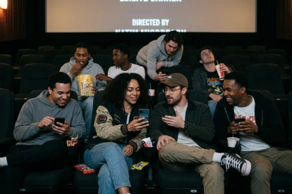 Grupo de jóvenes compartiendo en una sala de cine, generada con IA.