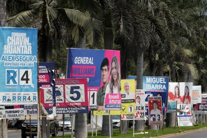 Fotografía que muestra carteles de candidatos electorales, en Lima (Perú).