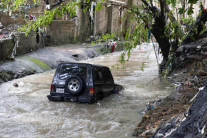 Un vehículo arrastrado a una cañada el 8 de abril de 2026, en Las 800, un barrio humilde en Santo Domingo (República Dominicana).