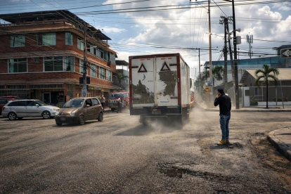 Un camión levanta polvo al circular por una deteriorada calle del centro de Durán, evidenciando el mal estado de la vía y las condiciones del tránsito en la zona.