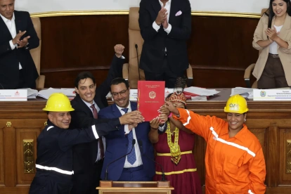 El presidente de la Asamblea Nacional de Venezuela, Jorge Rodríguez (arriba-c), y los vicepresidentes Pedro Infante y Grecia Colmenares, reaccionan luego de ser aprobada la nueva ley de minas..