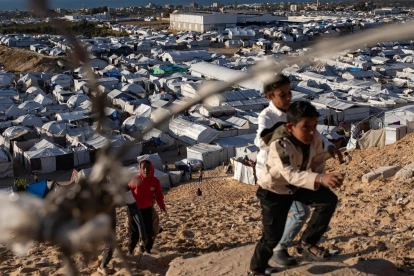 Niños palestinos desplazados juegan junto a sus tiendas de campaña dentro de un campamento de refugio temporal instalado en el sur de la Franja de Gaza.