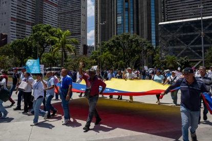 Personas participan en una manifestación de organizaciones sindicales, estudiantiles y gremiales para exigir aumentos salariales, en Caracas (Venezuela).