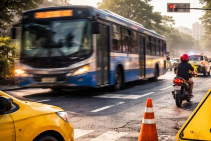 Un bus de transporte público circula por una intersección urbana mientras agentes realizan controles de tránsito para prevenir infracciones y siniestros viales.