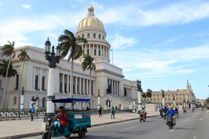Un triciclo y varias motocicletas eléctricas circulan frente al Capitolio este martes 14 de abril de 2026,en La Habana (Cuba).