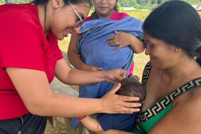 Médica aplica dosis de vacunas a un bebé, en una población de Ecuador.