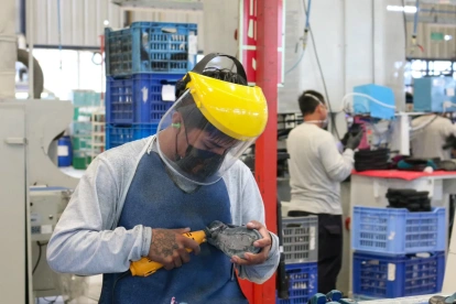 Trabajadores cumplen con su jornada laboral en una fábrica de zapatos.