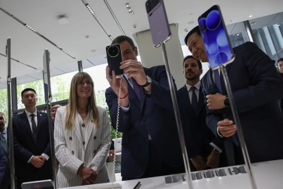 El presidente del Gobierno español, Pedro Sánchez), se toma una foto con un teléfono inteligente Xiaomi en presencia de su esposa, Begoña Gómez, en Pekín, el 13 de abril de 2026.