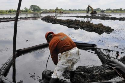 Fotografía de referencia de un empleado de la estatal Petróleos Mexicanos (Pemex) en medio de una extracción de crudo vertido durante un derrame de combustible.