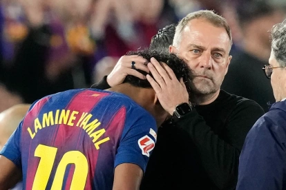 El delantero del FC Barcelona Lamine Yamal (i) junto a su entrenador Hans-Dieter Flick tras lesionarse, durante el partido de la jornada 33 de LaLiga que FC Barcelona y Celta de Vigo disputan hoy miércoles en el Camp Nou.