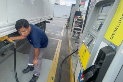 Trabajador carga diésel premium en camión en una gasolinera de Ecuador