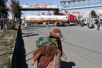 Una mujer aimara camina frente a un camión durante una jornada de protestas este lunes, en El Alto (Bolivia).