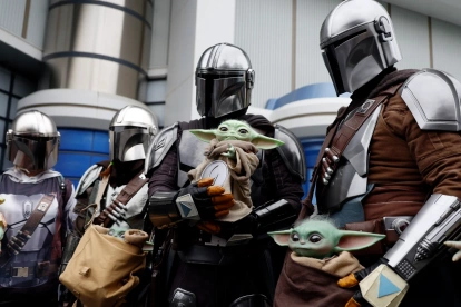 Visitantes caracterizados como personajes de The Mandalorian y Grogu posan frente a la atracción “Star Tours: The Adventures Continue” en Tokyo Disneyland, en Urayasu.