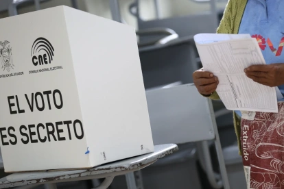 Ciudadana revisa su papeleta antes de ejercer el voto en un recinto electoral en Ecuador.
