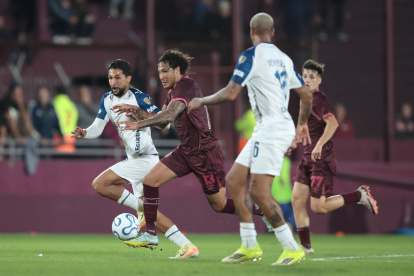 José María Canale (c) de Lanús disputa un balón con Jeison Medina (i) de Liga de Quito en el partido que los albos terminaron perdiendo 1-0  por la fase de grupos de la Copa Libertadores, en Argentina.