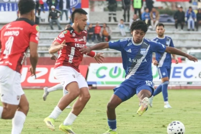 Luis Fragozo (d.) disputa el balón contra dos jugadores de Leones FC.
