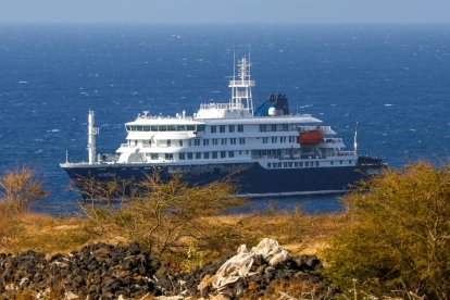 El crucero holandés MV Hondius (atrás), anclado frente a la costa de la ciudad de Praia en la isla de Santiago, Cabo Verde, este lunes 4 de mayo de 2026,