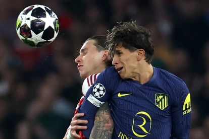 Riccardo Calafiori de Arsenal y Giuliano Simeone de Atlético de Madrid luchando la pelota.
