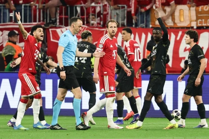 El árbitro portugués Joao Pinheiro y los reclamos de los jugadores del Bayern.