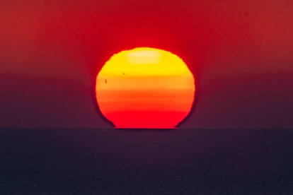 El sol se pone sobre la línea del horizonte en el mar, en una imagen de archivo.