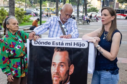 Familiares de Víctor Hugo Quero Navas, quien fue detenido hace más de un año en Venezuela, sostienen un cartel.