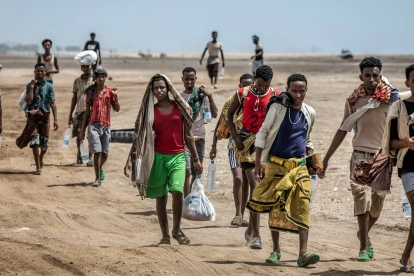 Miembros de la OIM asisten a un migrante etíope exhausto en una remota zona desértica.