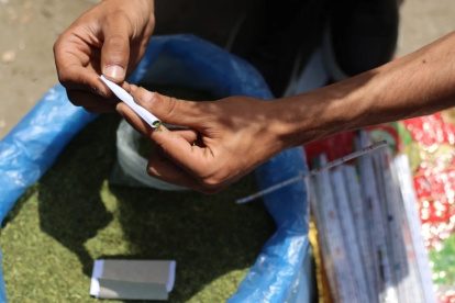 Un vendedor enrolla hojas de molokhia, también conocidas como malva de yute, que normalmente se usan en la cocina, para hacer un cigarrillo el 19 de abril de 2026.