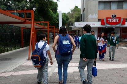 Una madre de familia recoge a sus hijos de una escuela primaria este lunes, en Ciudad de México (México).