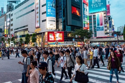 Fotografía de personas transitando un paisaje urbano en Japón.