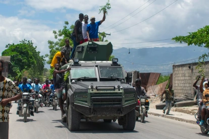 Personas celebran la llegada de la Policía Nacional Haitiana (PNH) a una zona del barrio Cité Soleil tras enfrentamientos entre grupos armados, en Puerto Príncipe (Haití).