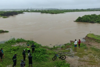 Fotografía de archivo que muestra a personas observando las inundaciones en la localidad de Chanduy en Santa Elena.