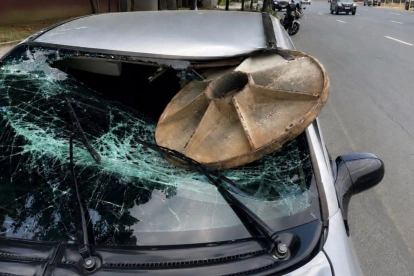 La tapa de la alcantarilla se incrustró en el parabrisas del automóvil, sobre el lado del conductor, quien recibió atención médica.